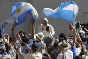 Faithful wave flags of Argentina as Pope Francis tours St. Peter's Square during his weekly general audience, at the Vatican, Wednesday, June 27, 2018. 