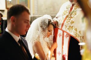 A priest blesses a newlywed couple. 