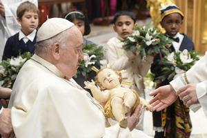 Pope Francis takes a figure of the Christ Child in his arms at the end of the Vatican Mass for the Nativity of the Lord on Dec. 24.