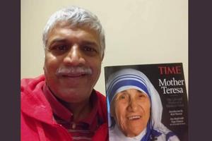 Patrick Norton pictured with a magazine cover of Mother Teresa, who picked him up from the streets of Bombay as an infant. Later he was adopted by an American family.