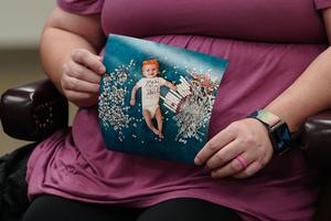Elizabeth Goldman, an in-vitro fertilization patient at the University of Alabama at Birmingham, holds up a photo of her daughter who was born via the procedure during a roundtable with U.S. Health and Human Services Secretary Xavier Becerra on February 27, 2024 in Birmingham, Alabama. 