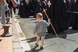 A child carries a cross in the Holy Week procession in Valencia, Spain.