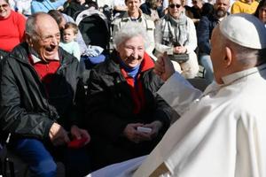 Pope Francis greets an elderly couple at a general audience in St. Peter's Square at the Vatican.