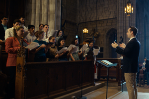Peter Carter directs a schola at Princeton University in a frame from a film about the project in the making.