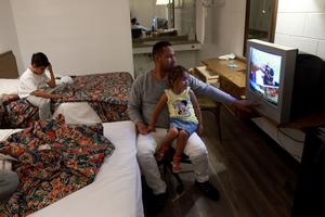 Jheanpiere Contreras, Daniel Soto, and Dainelys Soto, who two days ago arrived from Venezuela  after crossing the U.S. border from Mexico, relax in a hotel provided by the Annunciation House on September 22, 2022 in El Paso, Texas. 