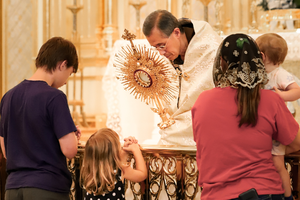A family adores Christ at an Adoration Sodality Day during adoration with Father Miguel Marie of the Franciscan Missionaries of the Eternal Word at the Shrine of the Most Blessed Sacrament.