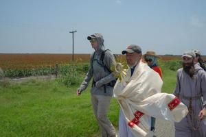 Charlie McCullough, in gray hoodie, walks with the Eucharistic procession through southern Texas.