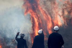 Local Druze men watch the flames burning a field after rockets launched from southern Lebanon landed on the Banias area in the Israel-annexed Golan Heights on June 9, 2024, amid ongoing cross-border clashes between Israeli troops and Hezbollah fighters. 