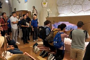 Tampa Jesuit students pray before the body of Blessed Carlos Acutis during a pilgrimage to Assisi, Italy. 