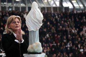 Mirjiana Dragicevic, one of the alleged visionaries, prays in front of a statue of Our Lady of Medjugorje, during a religious event in Naples, Italy. 