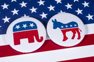 LONDON, UK - DECEMBER 18TH 2017: The Elephant symbol of the Republican Party and the Donkey symbol of the Democratic Party, with the American flag behind, on 18th December 2017.