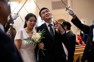 A groom flashes a peace sign at wedding-goers while processing out of St. Mary’s Church in Vancouver, British Columbia, Canada, after having his marriage sacramentally blessed at the Marriage Mass on Oct. 19, 2024.