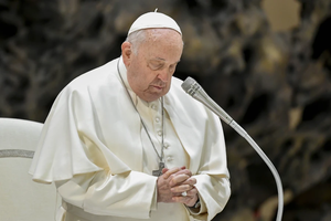 Pope Francis prays at his general audience Dec. 20, 2023, in Paul VI Hall at the Vatican.