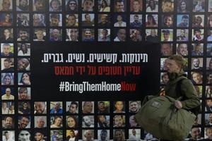 A soldier passes by a wall covered with photos of hostages held by Hamas after the deadly Oct. 7, 2023, attack in a Tel Aviv train station on Jan. 14, 2025, Tel Aviv, Israel. 