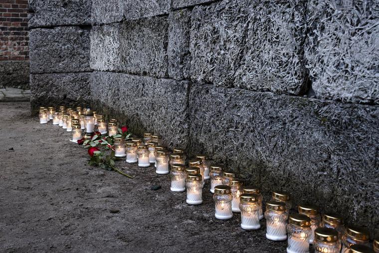 Candles and wreaths left by Auschwitz survivors stand at the so-called ‘Death Wall’ at the Auschwitz I site on the 80th anniversary of the liberation of the Nazi death camp on Jan. 27, 2025, in Oswiecim, Poland. 