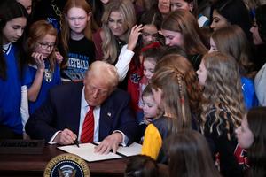 U.S. President Donald Trump, joined by women athletes, signs an executive order in the East Room at the White House on Feb. 5, 2025, in Washington. The executive order, which Trump signed on National Girls and Women in Sports Day, prohibits transgender women from competing in female sports. 