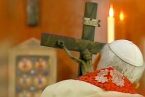 Too ill to attend in person, Pope John Paul II holds close to a crucifix carved by Stanisław Trafalski on Good Friday 2005 while viewing the Stations of the Cross on broadcast television. 