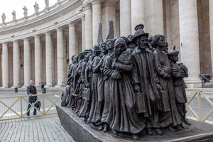 Canadian sculptor Timothy P. Schmalz poses next to his sculpture on the theme of refugees and migration, “Angels Unawares,” in St. Peter’s Square at the Vatican.