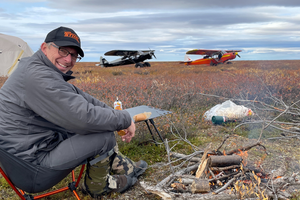 Sean McLaughlin, shown in foreground with bush planes in the background
