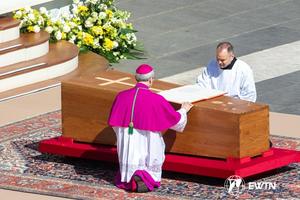 Archbishop Diego Giovanni Ravelli kneels next to the casket holding the remains of Pope Francis during the funeral Mass in St. Peter's Square on April 26, 2025.