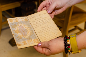 Archivists show a handwritten book of the Rule of St. Augustine found in the Sisters of Charity of St. Augustine’s archives, an example of the materials that will be preserved in WRAC’s future heritage center.