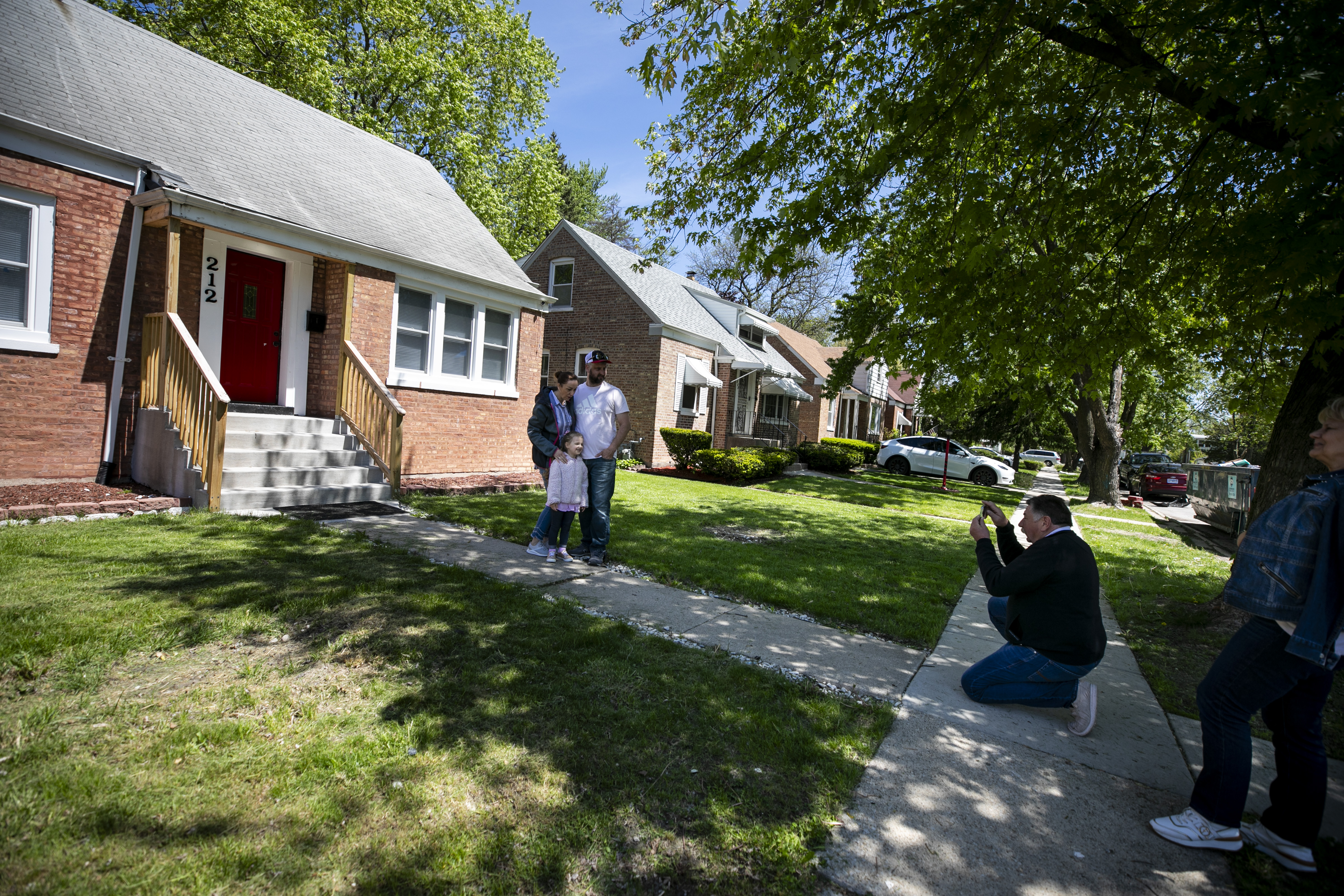 Andszej Pielat, right, takes a photo of his niece Joanna Radbecki, her husband Michael and their daughter Michelle as they pose for a picture at the childhood home of Pope Leo XIV in Dolton, on Friday May 9, 2025.
