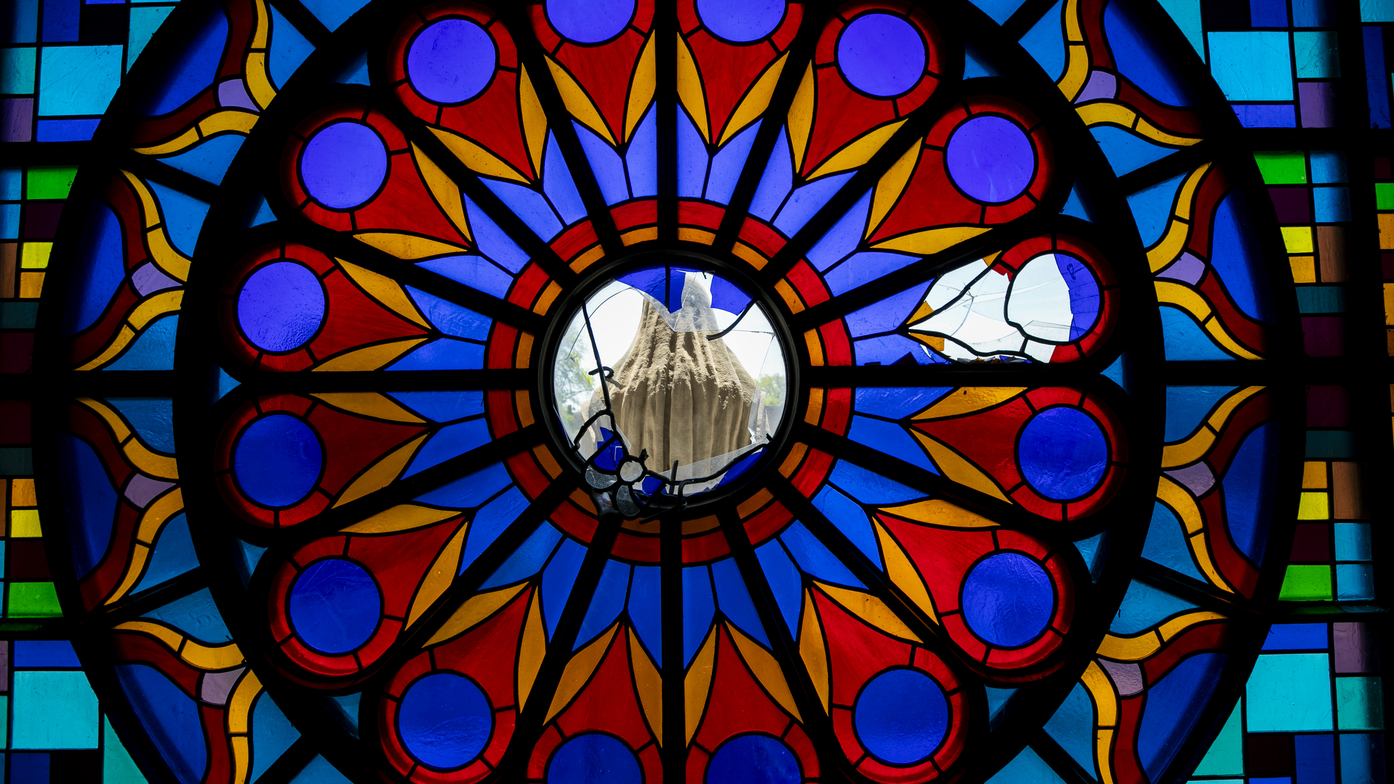 A broken stain-glass window with a statue of Mary sit above the main entrance to St. Mary’s Church, in Chicago, on Friday May 9, 2025. The church and connected school were where Pope Leo XIV attended Mass and grade school.