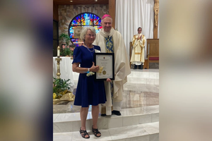 Jeanne Vath Ory receives her Regina Matrum Award after a special vigil Mass was celebrated by New Orleans Archbishop Gregory Aymond at her home parish, St. Joan of Arc in LaPlace, Louisiana, on May 12, 2025, the day after Mother’s Day.