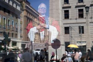 A projection of Pope Leo XIV is seen Friday in a shop display window near the Vatican. More than 100,000 faithful from 100 countries are expected to convene in Rome for Jubilee events culminating at Pope Leo XIV's inaugural Mass at the Vatican.
