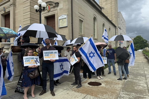 Participants at a May 22, 2025, afternoon vigil to honor the two lives lost in an attack outside the Capital Jewish Museum in Washington, D.C., the night before hold signs reading “Christians and Jews united against hate.”