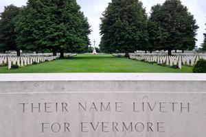 A stone marker bearing the inscription “Their Name Liveth Forevermore” stands among the graves of fallen soldiers at the Normandy American Cemetery and Memorial in Colleville-sur-Mer, France. The cemetery overlooks Omaha Beach and honors the 9,388 American servicemembers who gave their lives during the D-Day landings and subsequent operations in World War II.