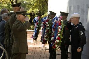Marines and a sailor salute during the playing of Taps at the Beirut Memorial Ceremony on Oct. 23, 2015, at Lejeune Memorial Gardens in Jacksonville, North Carolina, honoring those killed in the 1983 Marine barracks bombing in Lebanon.