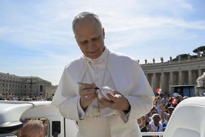 Pope Leo XIV signs a baseball at his June 4, 2025, general audience. The Pope is a fan of the Chicago White Sox.