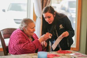 A Catholic Charities Bureau employee assists with a craft.