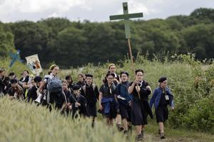 Young people hold crosses as they arrive for Mass during the traditional Pentecostal pilgrimage from Paris to Chartres, in Sonchamp, near Paris, on June 8, 2025. 