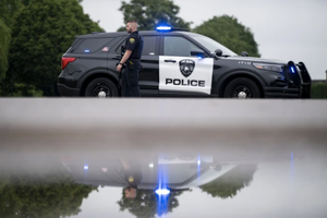 A Brooklyn Park police officer looks on while guarding the entrance to a neighborhood on June 14, 2025, in Brooklyn Park, Minnesota. 