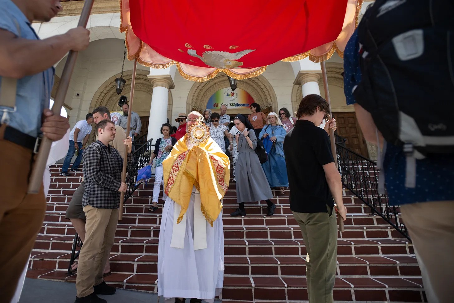 The Blessed Sacrament is brought down the steps of the Cathedral of St. Joseph in San Diego following Adoration and Benediction, as pilgrims and religious gather around in reverence.