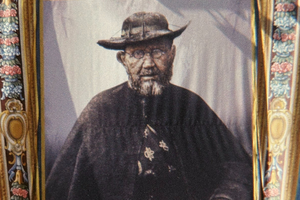A photograph of Father Damien De Veuster taken shortly before his death adorns the canonization tapestry of St. Damien at his birthplace museum.