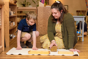 Cassandra Baker, now a coordinator for the Catholic Montessori Institute, presents a math lesson introducing the decimal system to a 4-year-old student in spring 2023 at the Christ the King Catholic Montessori Grade School in Mandan, North Dakota.