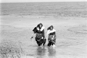 Two religious sisters wade into shallow water to dig for clams on Long Island, New York, September 1957.