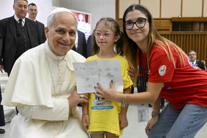 Pope Leo XIV receives a drawing from a girl participating in the “Estate Ragazzi in Vatican” summer camp on July 3, 2025, at the Vatican.