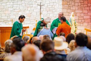 Archbishop Gustavo García-Siller of San Antonio hugs Rosalie Castro, whose nephew was rescued from the flood, during Mass at Notre Dame Catholic Church in Kerrville, Texas, on Sunday, July 6, 2025.