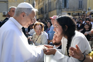 Pope Leo XIV greets a young woman along the streets of Albano, Italy, before offering Mass in the Cathedral Basilica of Saint Pancras near Castel Gandolfo on July 20, 2025.