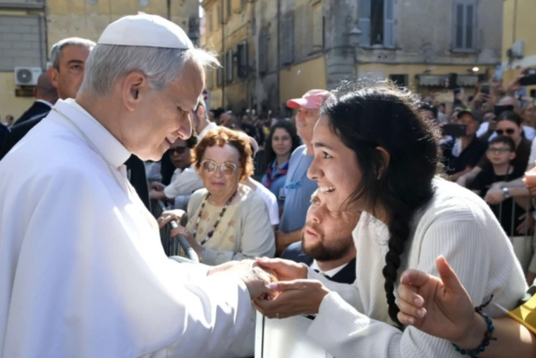 Pope Leo XIV greets a young woman along the streets of Albano, Italy, before offering Mass in the Cathedral Basilica of Saint Pancras near Castel Gandolfo on July 20, 2025.