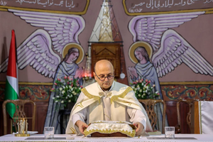 Father Gabriel Romanelli, parish priest at the Roman Catholic Church of the Holy Family, who was wounded in a recent strike on the church, stands before the altar during a Sunday morning Mass held by the Latin patriarch of Jerusalem at the church in Gaza City on July 20, 2025. 