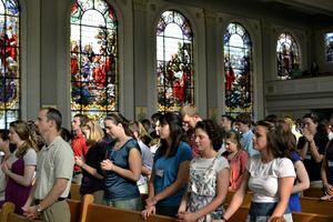 Catholic young people pray together at Mass.