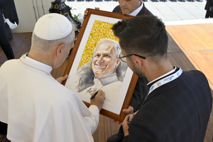 Pope Leo XIV signs a portrait of himself for a pilgrim at his general audience on July 30, 2025, in St. Peter’s Square at the Vatican.