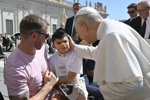 Pope Leo blesses a child at his July 30, 2025, general audience.