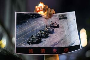 A man holds a poster of the famous 'Tank Man' standing in front of Chinese military tanks at Tiananmen Square in Beijing on June 5, 1989, during a candlelit remembrance in Victoria Park in Hong Kong on June 4, 2020. A man holds a poster of the famous 'Tank Man' standing in front of Chinese military tanks at Tiananmen Square in Beijing on June 5, 1989, during a candlelit remembrance in Victoria Park in Hong Kong on June 4, 2020.
