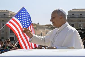 American-born Pope Leo waves to the faithful during his Aug. 6, 2025, general audience as the flag of his homeland flies in St. Peter’s Square. Aug. 16 marks the first 100 days of his pontificate.